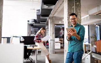 Young man using technology, digital tablet in corporate business office